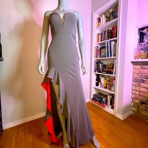 Elegant maxi, strapless dress with slit and red lining. Form fitting.